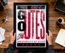 A framed poster with the text "GUES" and "UNIVERSITY OF UTAH" is being held by a person's hands.
