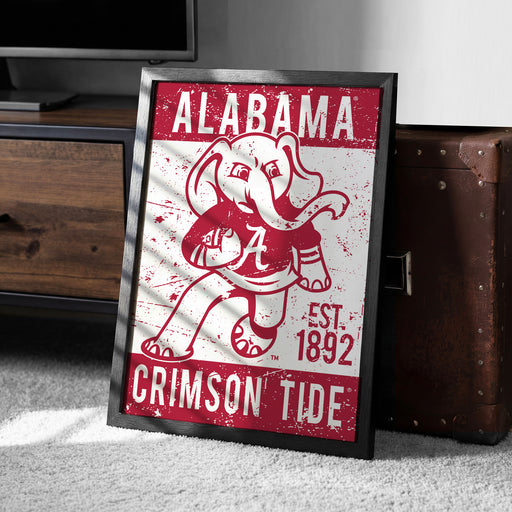 A framed poster featuring the Alabama Crimson Tide football team logo and text, with a vintage, distressed appearance.