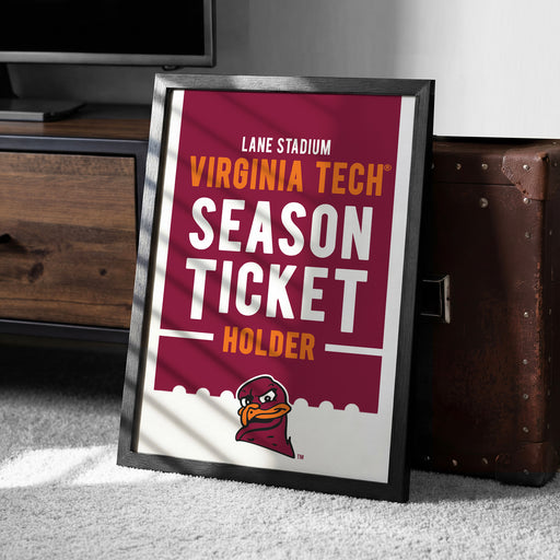 A framed poster advertising Virginia Tech's season ticket holder, featuring the university's logo and text.