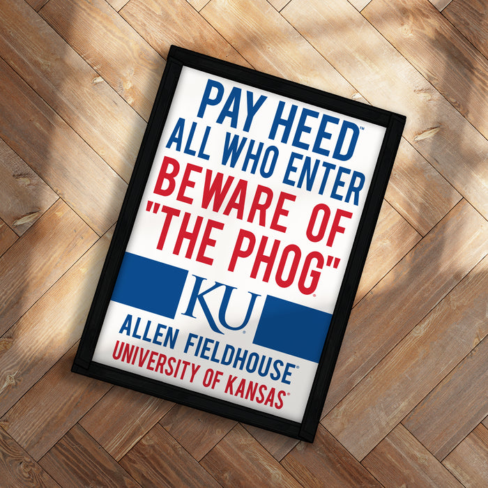 A framed poster with the text "PAY HEED ALL WHO ENTER BEWARE OF THE PHOG" and the university's logo, placed on a wooden floor.