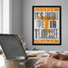 a framed poster with the text "It's Football Time in Tennessee" hanging on a wall above a desk with a laptop and other office supplies.