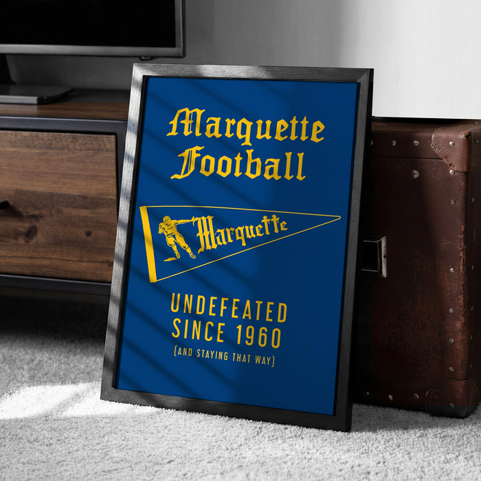 A framed poster with the text "Marquette Football" and a yellow flag, along with the text "UNDEFEATED SINCE 1960 (AND STAYING THAT WAY)".