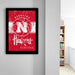 a framed poster of the Nebraska Huskies basketball team, with the team's logo and text prominently displayed.