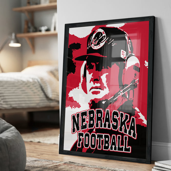 A framed poster of a man wearing a Nebraska football hat, with the text "NEBRASKA FOOTBALL" prominently displayed.