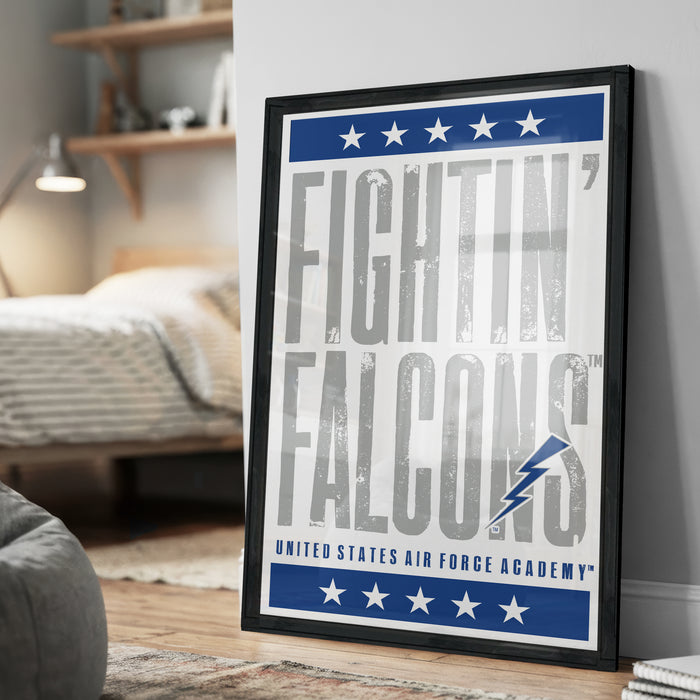 a framed poster with the text "FIGHTIN' FALCONS" and "United States Air Force Academy" on it, placed on a wall in a bedroom setting.