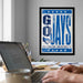 A framed poster with the text "GOLAYS" is displayed on a wall above a desk with a laptop and other office supplies.