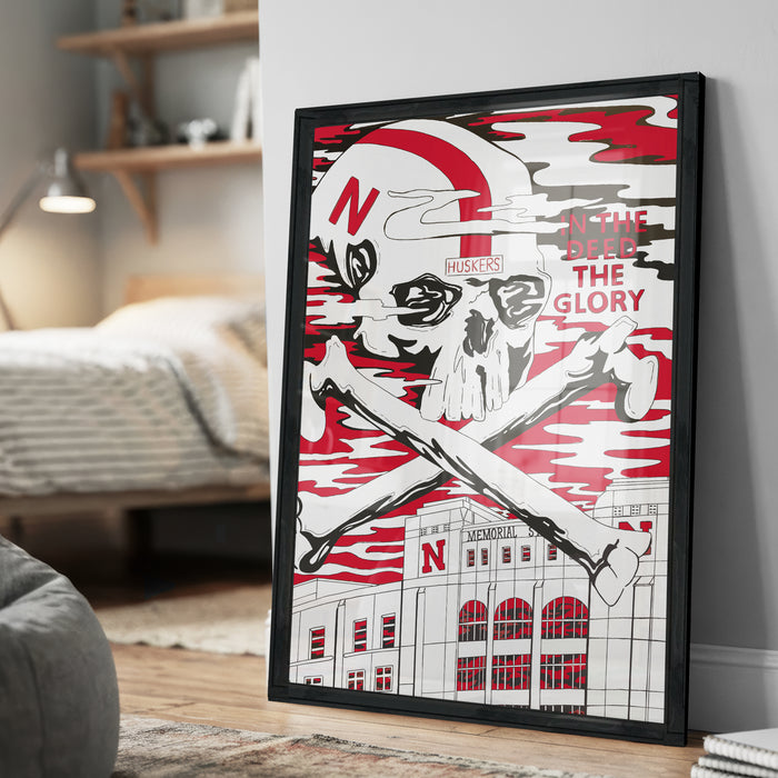 A framed poster featuring a skull and crossbones design with the text "HUSKERS" and "IN THE DEED THE GLORY" prominently displayed.