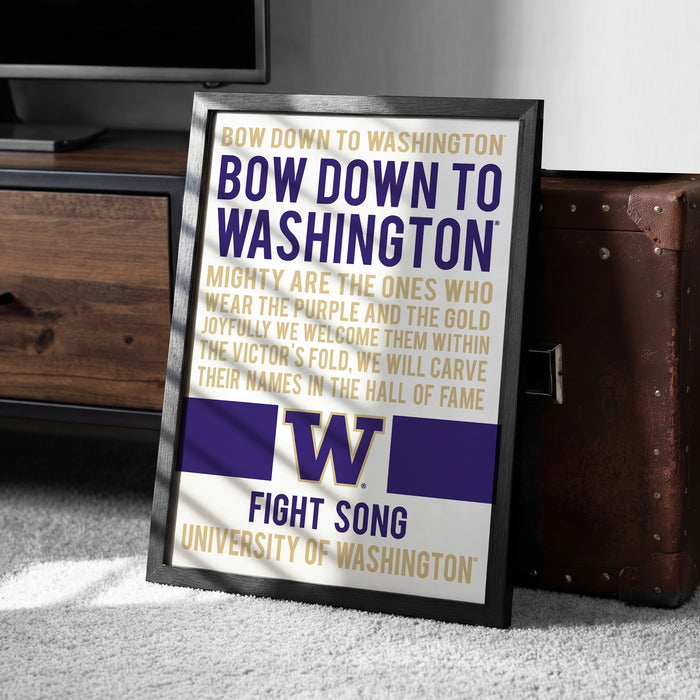 a framed poster with text and a logo, placed on a carpeted floor next to a wooden chest.