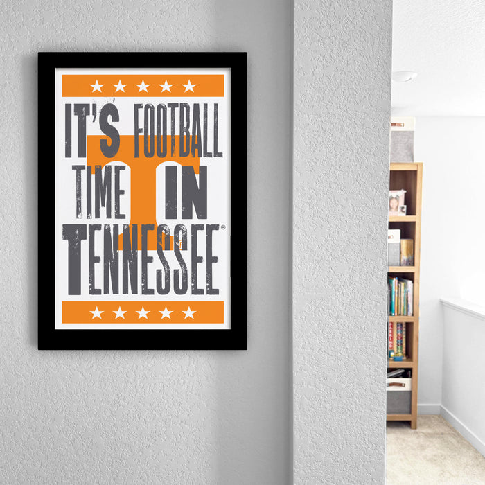 A framed poster with the text "IT'S FOOTBALL TIME IN TENNESSEE" is hanging on a wall.