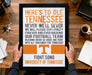 A person is holding up a framed poster with the text "HERE'S TO OLE TENNESSEE" and "FIGHT SONG UNIVERSITY OF TENNESSEE" printed on it.