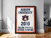 a framed poster with the text "Auburn University 2010 College Football National Champions" displayed prominently.