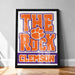 A framed poster with the text "THE ROCK CLESMONT" and an orange paw print logo, representing the University of South Carolina's football team.