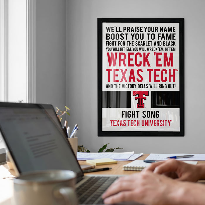 a poster with a message encouraging people to "WRECK 'EM TEXAS TECH' and the victory bells will ring out!" The poster is displayed on a wall, and there is a laptop and a person's hands visible in the foreground.