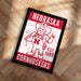 A framed poster featuring the Nebraska Cornhuskers, a sports team, with a cartoon illustration of a cornhusker mascot.