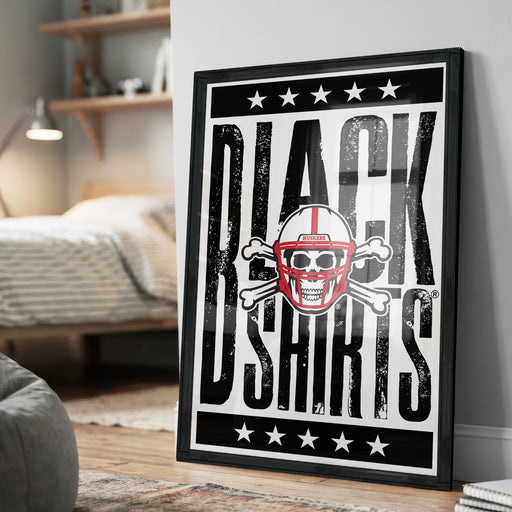 A framed poster with the text "BLACK SHIRTS" and a graphic of a skull wearing a football helmet, placed on a wall in a bedroom.