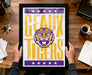 A framed poster with the text "GEAUX TIGERS" and a graphic of a tiger is being held by a person's hands.