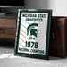 A framed sign displaying the Michigan State University logo and text, indicating that the university was a national championship winner in 1979.
