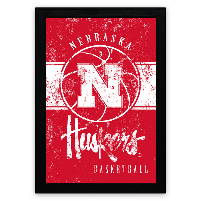A framed poster featuring the logo and text for the Nebraska Huskers basketball team.