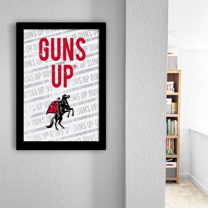 a framed poster with the text "GUNS UP" displayed prominently.