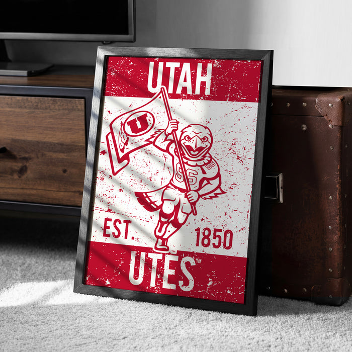 A framed poster of a Utah football team logo, featuring a mascot holding a flag and the text "UTAH EST. 1850 Utes".