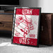 A framed poster of a Utah football team logo, featuring a mascot holding a flag and the text "UTAH EST. 1850 Utes".