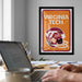 a framed poster of a football helmet with the text "VIRGINIA TECH" on it, hanging on a wall above a desk with a laptop and other items on it.