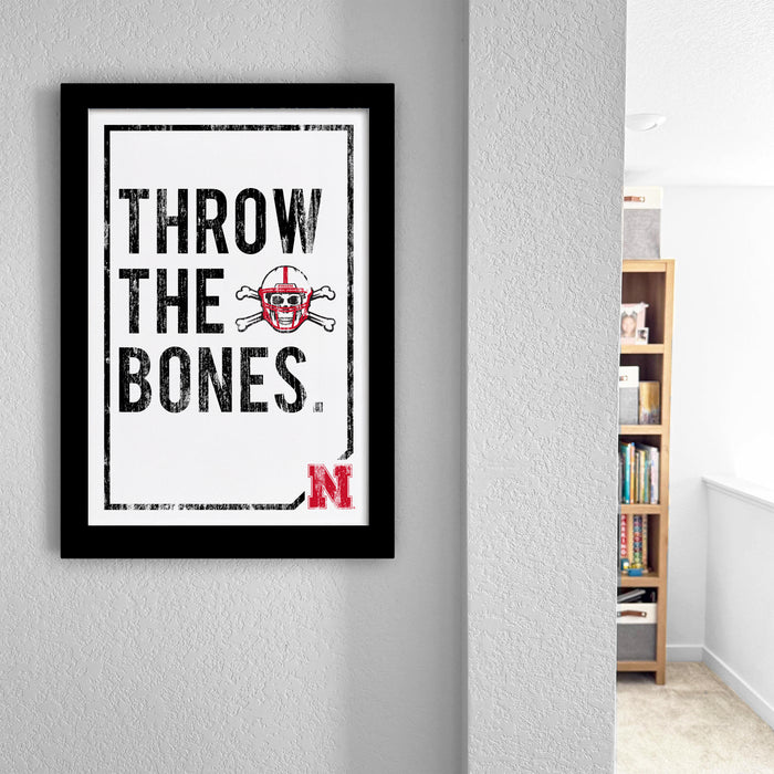 a framed poster with the text "THROW THE BONES" and a skull and crossbones symbol.