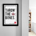 a framed poster with the text "THROW THE BONES" and a skull and crossbones symbol.