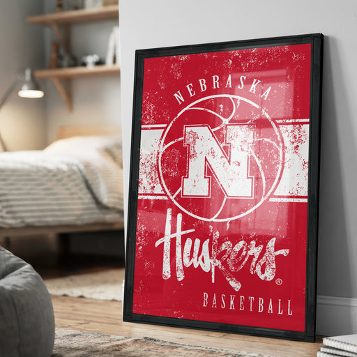 A framed poster of the Nebraska Huskies basketball team, featuring the team's logo and text.