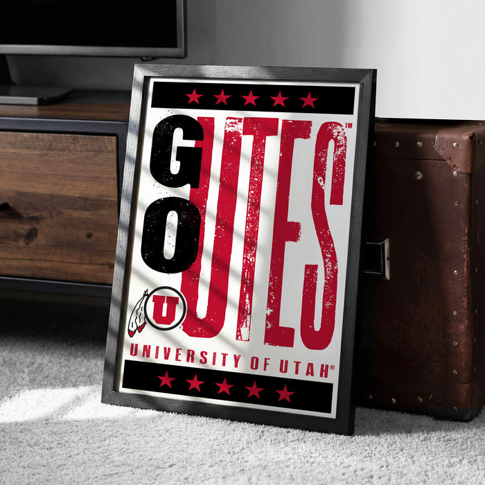 A framed poster with the text "GOUTES UNIVERSITY OF UTAH" is displayed on a carpeted floor next to a wooden chest.