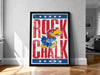 A framed poster featuring the Kansas City Royals logo and the text "ROCK CHALK" is displayed on a wall in a room.