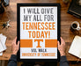 A person is holding up a framed sign with the text "I WILL GIVE MY ALL FOR TENNESSEE TODAY!" The sign is for the "VOL WALK UNIVERSITY OF TENNESSEE".