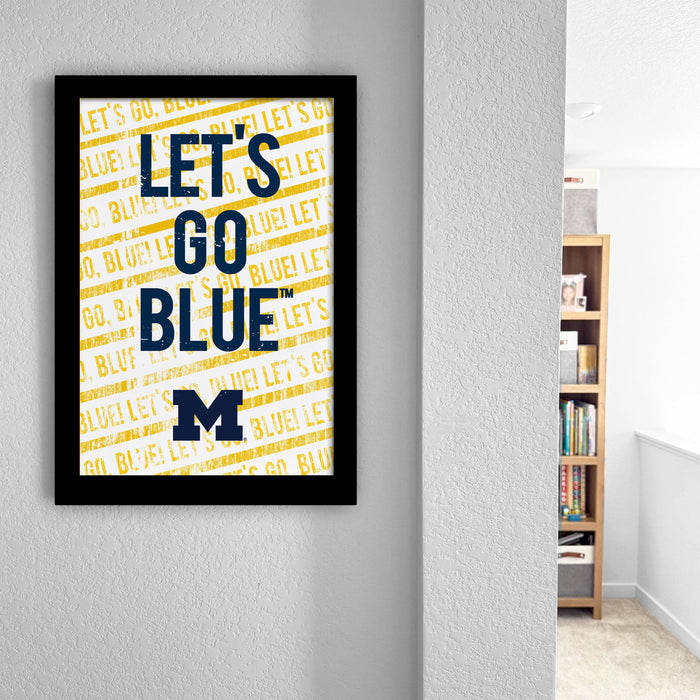 a framed poster with the text "LET'S GO BLUE" on it, which is displayed on a wall in a room.