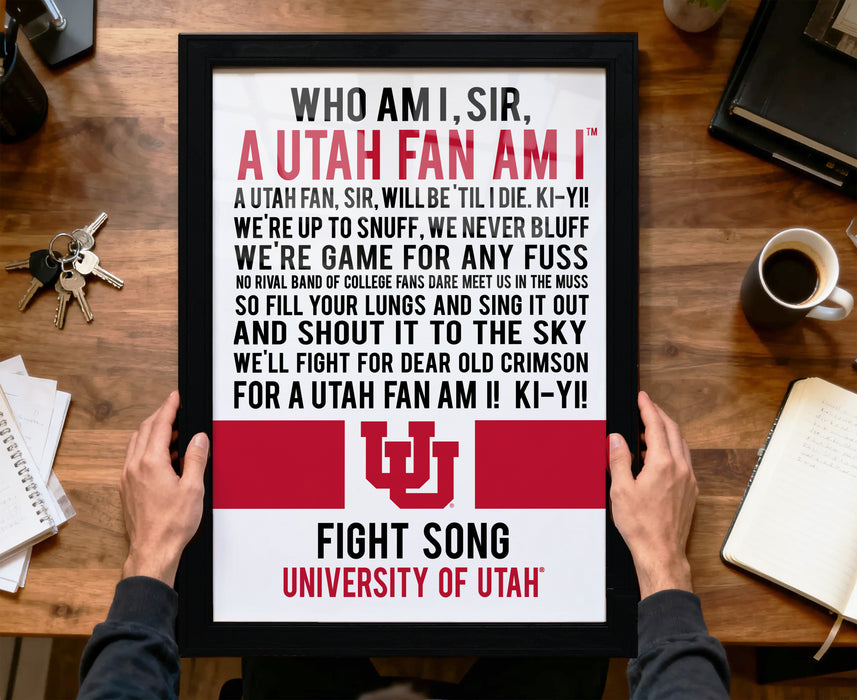 A person is holding a framed poster with text on it, which appears to be a message from Utah University.