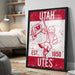 A framed poster featuring a graphic of a person holding a flag, with the text "UTAH EST. 1850 UTES" prominently displayed.