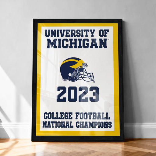 A framed poster with the text "UNIVERSITY OF MICHIGAN" and "2023 COLLEGE FOOTBALL NATIONAL CHAMPIONS" on it, along with a football helmet and the year "2023".