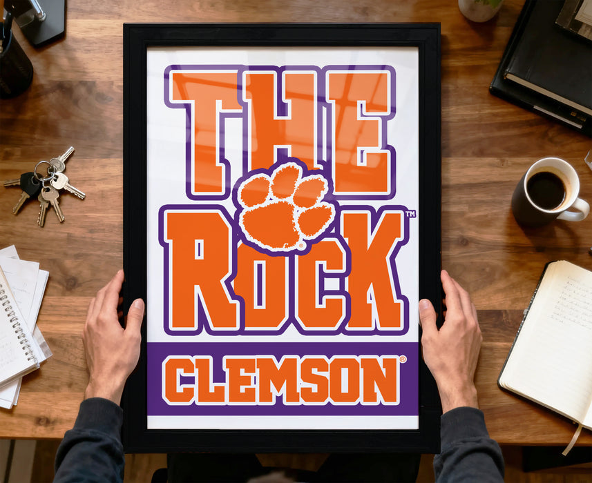A framed poster with the text "THE ROCK CLIMB" and a large orange paw print, representing the University of South Carolina's football team.